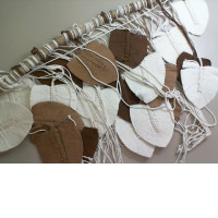 Decorative curtain for the wall made of threads, on a wooden stick