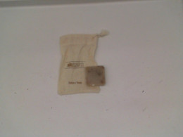 Small bar of soap in a small cream colored cloth bag 