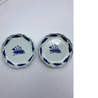 Set of 2 The white saucer has a blue sailboat pattern. 