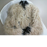 Women's short jacket with fur in a cover on a hanger