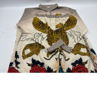  Cream long-sleeved shirt with leopard print and cream pants with leopard print. 