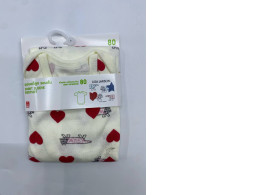 White baby bodysuit with red heart pattern 