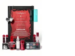Sheglam cosmetics gift set. The set includes three lipsticks, a heart pendant, an eyeshadow palette, foundation, makeup remover serum, shimmery body lotion, and clear lip gloss.
