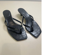 Women's black open toe flip flops with a small heel
