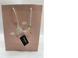 pink paper gift bag from the brand Moshi Moshi, featuring a "Lovely Bunny" design. 