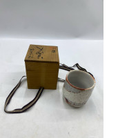 A Japanese matcha green tea cup, served in a traditional wooden box (kiribako). A Japanese matcha green tea cup, served in a traditional wooden box (kiribako).