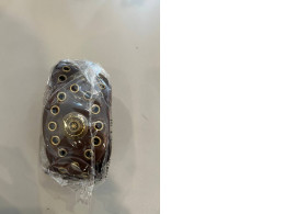  brown leather-look western-style belt with gold-tone metal eyelets and a decorative center buckle design. 