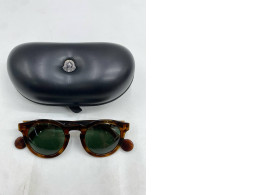 pair of Moncler round tortoiseshell sunglasses with a black case. pair of Moncler round tortoiseshell sunglasses with a black case.