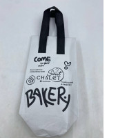  white and black non-woven fabric tote bag with the "Sweet CHALET BAKERY" logo and branding. 