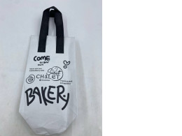 white and black non-woven fabric tote bag with the "Sweet CHALET BAKERY" logo and branding. white and black non-woven fabric tote bag with the "Sweet CHALET BAKERY" logo and branding.