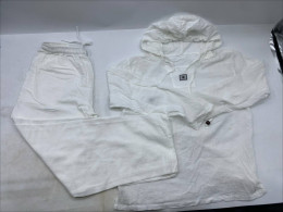 White trousers and a white long-sleeved hooded shirt.