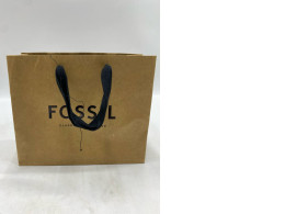 brown Fossil paper gift bag with black rope handles. 