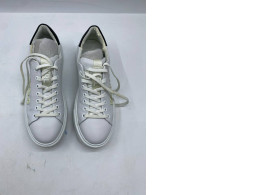 Low-top white leather sneakers with a black stripe on the heel and white laces.
