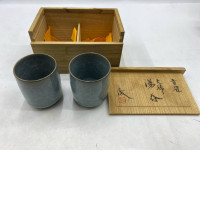 be a set of Japanese ceramic tea bowls, known as chawan, presented in a wooden storage box. 