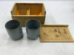 be a set of Japanese ceramic tea bowls, known as chawan, presented in a wooden storage box. 