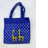 blue tote bag with a white heart and yellow giraffe pattern.