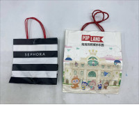 Set of 2 shopping bags: a black-and-white striped Sephora bag and a white bag from Pop Mart 