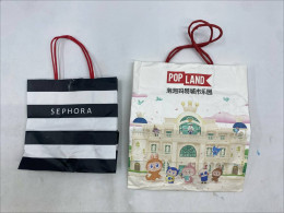 Set of 2 shopping bags: a black-and-white striped Sephora bag and a white bag from Pop Mart 