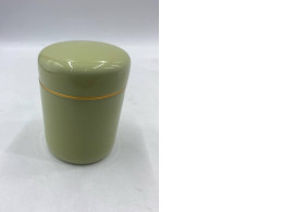An empty olive green metal tea tin with a gold band.