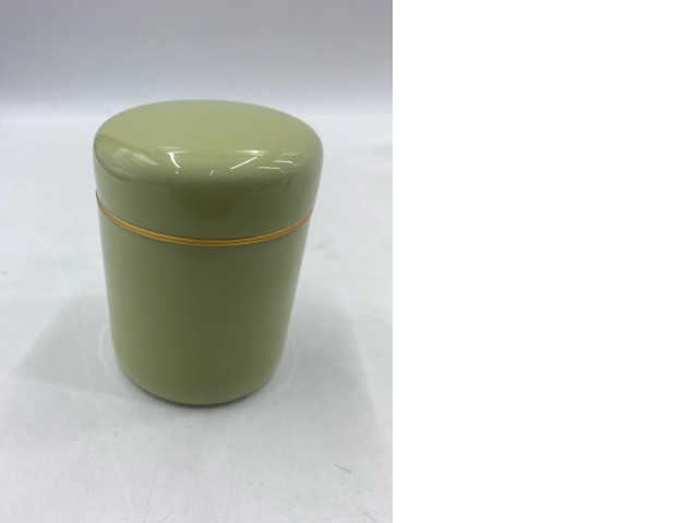 An empty olive green metal tea tin with a gold band. An empty olive green metal tea tin with a gold band.