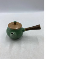 Green teapot with wooden handle on the side. Green teapot with wooden handle on the side.