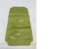 Olive green coaster/placemat with cloud and crane pattern.