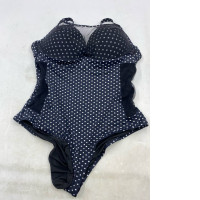 One-piece swimsuit with navy blue and white polka dots.