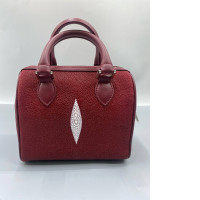 Red faux stingray leather handbag with rolled-up top handles and a top zipper closure.