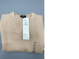 Uniqlo crew neck sweater in a light beige color, made from a blend of cotton, polyester, and viscose/rayon. 