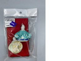 Two small, hand-painted ceramic figurines, possibly in the Arita pottery style.