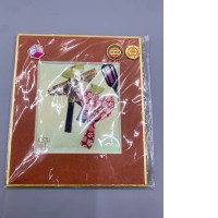 Japanese handmade paper art, especially oshie or washiningyo (cloth/paper dolls), depicts a replica of a musician strolling, enclosed in protective plastic with a gold border and a certification seal.