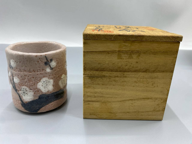 Japanese tea cup with cherry blossom design, in a wooden box. Japanese tea cup with cherry blossom design, in a wooden box.