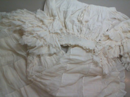 A suit with a full skirt and a white top with puffy sleeves