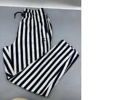 Women's white trousers with black stripes.