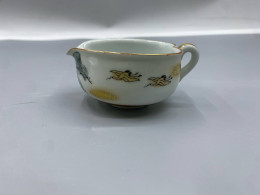 Japanese Kutani porcelain piece, likely from a tea set, featuring crane and pine tree motifs with gold accents. 