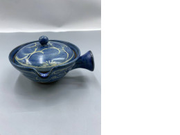 A small, Japanese-style glass baking pot, glazed in blue and decorated with delicate floral or vine patterns.