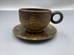A tea set consisting of a cup and saucer made from coconut wood, often produced by Pvplusproduction.