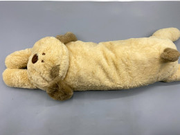 beige, long-bodied dog plush toy designed to resemble a sleeping or lying animal. beige, long-bodied dog plush toy designed to resemble a sleeping or lying animal.