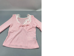 pink long-sleeved top featuring a sweetheart neckline with white lace patchwork detailing. 