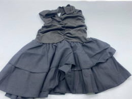A black women's dress with a halter neck, featuring a pleated bodice and a layered ruffled skirt.