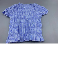 The Damson Madder Becca blouse is characterized by its pleated bodice, puffed sleeves, and stripes.
