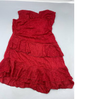 A vintage-style, strapless red cocktail dress with layered ruffle details, reminiscent of styles from the early 2000s.