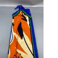 This vibrant, halter-neck maxi dress features a striking pattern of bright orange, blue, and green.