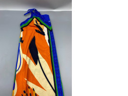 This vibrant, halter-neck maxi dress features a striking pattern of bright orange, blue, and green.