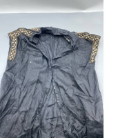 A black, button-down denim shirt with embroidered details on the shoulders, reminiscent of the style presented by designers like Dolce & Gabbana.