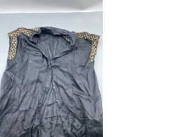 A black, button-down denim shirt with embroidered details on the shoulders, reminiscent of the style presented by designers like Dolce & Gabbana.