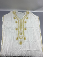 white embroidered dashiki or kaftan dress, commonly styled with gold thread detailing around the neckline. 