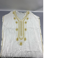 white embroidered dashiki or kaftan dress, commonly styled with gold thread detailing around the neckline. white embroidered dashiki or kaftan dress, commonly styled with gold thread detailing around the neckline.