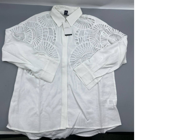 white blouse from Shoeby, featuring prominent geometric laser-cut designs on the shoulders and chest. white blouse from Shoeby, featuring prominent geometric laser-cut designs on the shoulders and chest.
