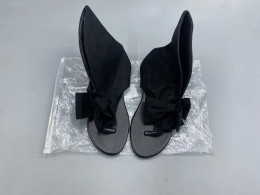 Black suede slingback sandals with bow embellishment for women.